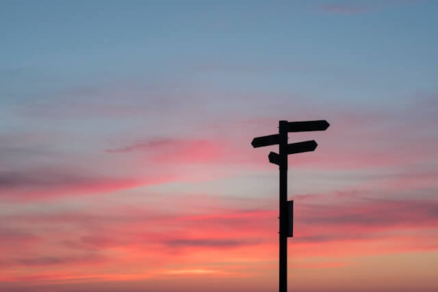 A sunset with a sign, photo by Javier Allegue Barros on Unsplash